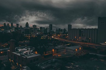 time-lapse photography of city under black cloudy sky