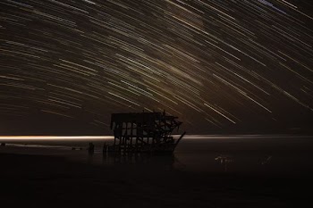 time lapse photography of house with shooting star at night time