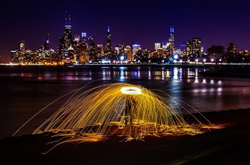 Time-lapse Photography of Person Beside Body of Water Overlooking City Scape