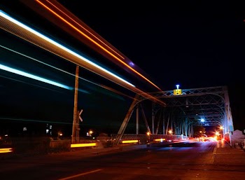 time lapse photography of vehicles crossing suspension bridge