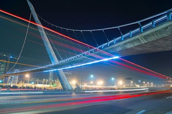 time lapse photography of vehicles under concrete bridge at nighttime