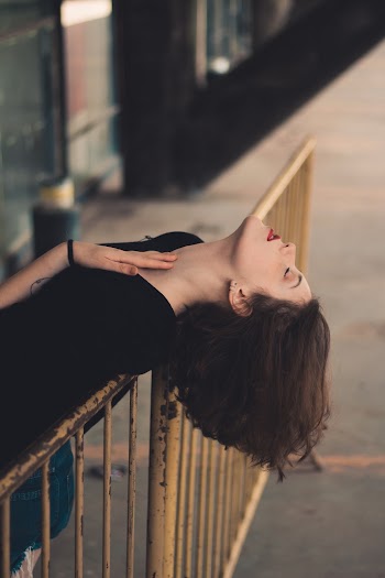 Time-lapse Photography of Woman Leaning Against Metal Fence