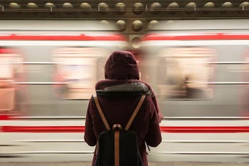 time-lapse photography of woman standing in front of train
