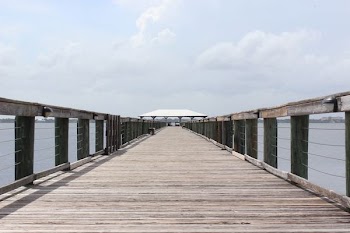 time lapse photography of wooden bridge under cloudy sky