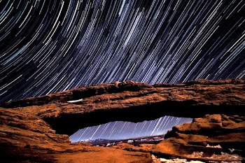 timelapse photo of stars and brown rock arch