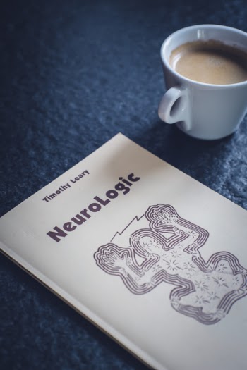 Timothy Leary's Neurologic Book Near White Ceramic Cup