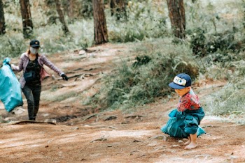 Toddler Carrying Blue Sack Outdoors
