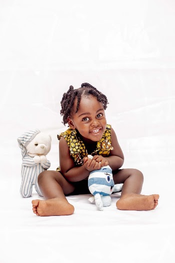 Toddler Girl Smiling and Touching Toy