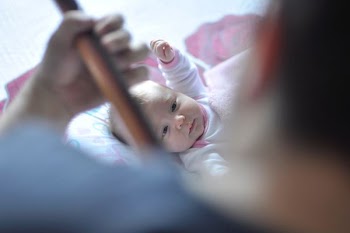 toddler lying on bed with comforter