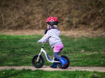 Toddler Riding Balance Bike on Grass
