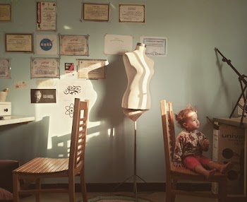 Toddler Sitting on Brown Wooden Chair