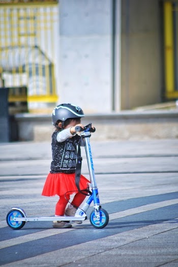 Toddler Using Scooter on Road