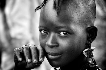 toddler with earrings putting her hand on her face in selective focus greyscale portrait photography