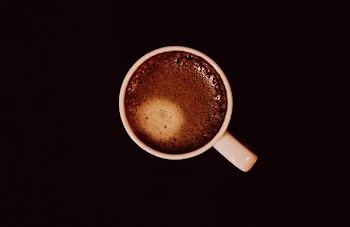 top view of white ceramic mug with brown liquid