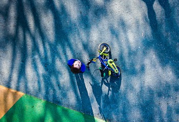 Top View Photo of Kid Near Bicycle