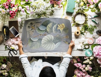 Top View Photo of Person Holding Floral Painting
