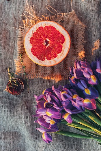 Top View Photo of Sliced Orange Near Flowers