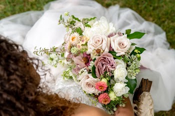 Top View Photography Of Bride Sitting On Grass While Holding Flower Bouquet