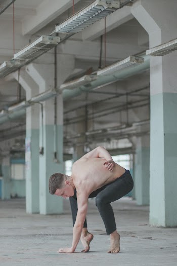 Topless Man Doing Exercise Near White Building