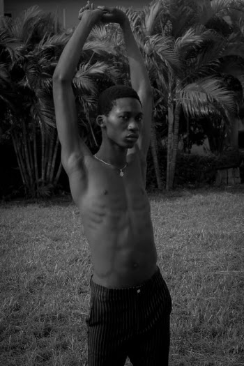 Topless Man in Black and White Shorts Standing on Grass Field · Free Stock Photo
