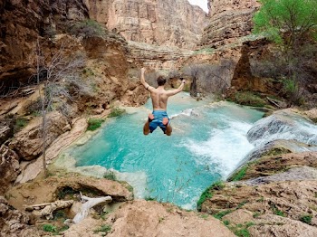 Topless Man Jumping on Body of Water