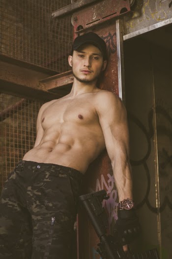Topless Man Leaning Door While Holding the Rifle