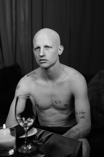 Topless Man Sitting Beside Table With Wine Glass