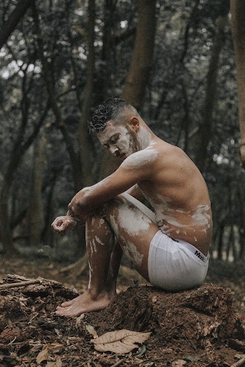 Topless Man Sitting Outdoors