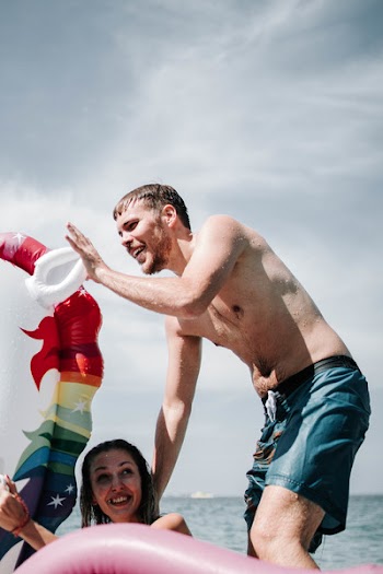Topless Man Standing Behind Woman
