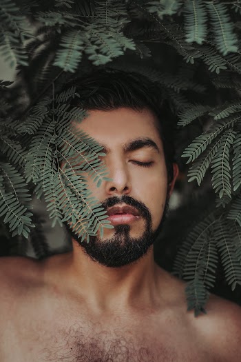 Topless Man Standing Beside Green Plant