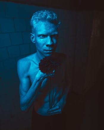 Topless Man Standing Inside Dimmed Blue Lighted Room
