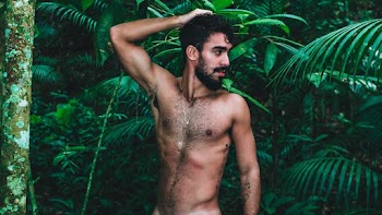 Topless Man Standing Near Green Plants with His Hand on His Head