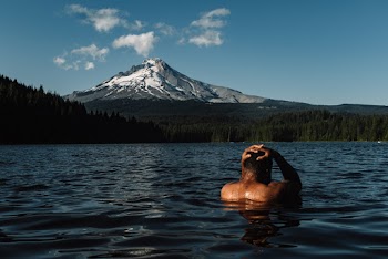 Topless Man Swimming On Lake