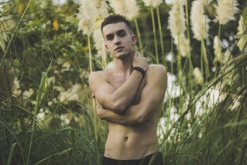 Topless Man Wearing Black Bottoms Surrounded By Green Grass