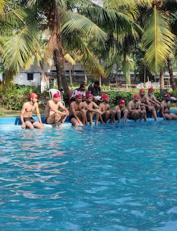Topless Men Sitting On Pool Side