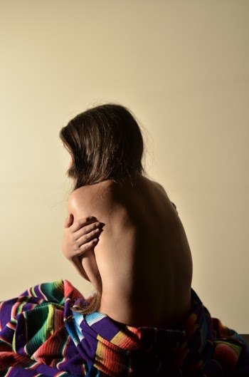 Topless Woman Hugging Herself Inside Yellow Painted Room