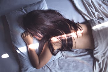 Topless Woman Lying on Bed