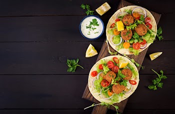 Tortilla wrap with falafel and fresh salad. vegan tacos. vegetarian healthy food. top view Free Photo