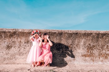 Tow Girls Sitting Beside Concrete Wall