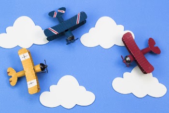 toy aircraft on a background of blue sky with paper clouds. The...