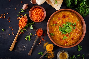Traditional indian soup lentils. indian dhal spicy curry in bowl, spices, herbs, rustic black wooden table Free Photo