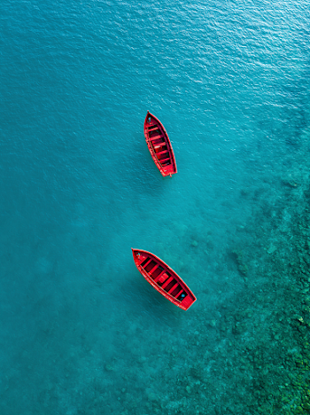 Tranquil Aerial View of Red Boats on Crystal Clear Water