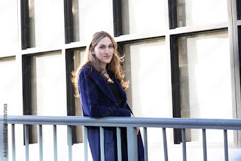 Trans woman posing next to a railing.