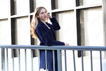 Trans woman posing next to a railing.