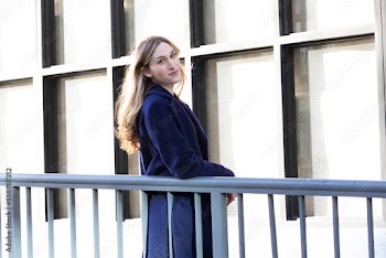Trans woman posing next to a railing.