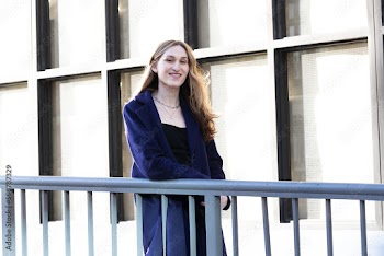 Trans woman posing next to a railing.
