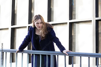 Trans woman posing next to a railing.