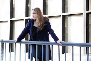 Trans woman posing next to a railing.