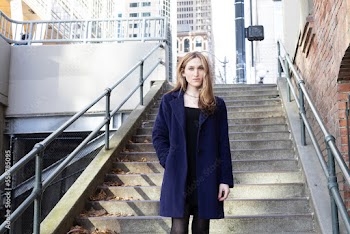 Trans woman posing on stairs outside.