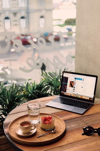 Tray of Fruits and Coffee Near Powered-on Laptop on Brown Table